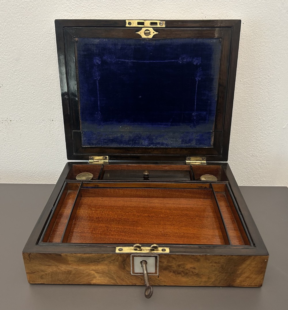 A rectangular Victorian burr walnut box featuring rounded edges, a mother-of-pearl central cartouche inlay, and a matching keyhole escutcheon. View X