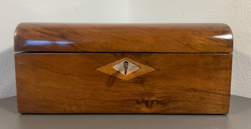 Victorian burr walnut wooden box with a geometric mosaic inlay border, central mother of pearl lozenge motif, and key in the front lock. View V