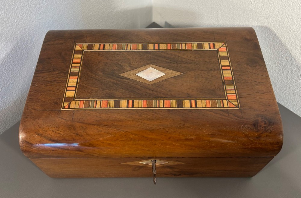 Victorian burr walnut wooden box with a geometric mosaic inlay border, central mother of pearl lozenge motif, and key in the front lock. View X