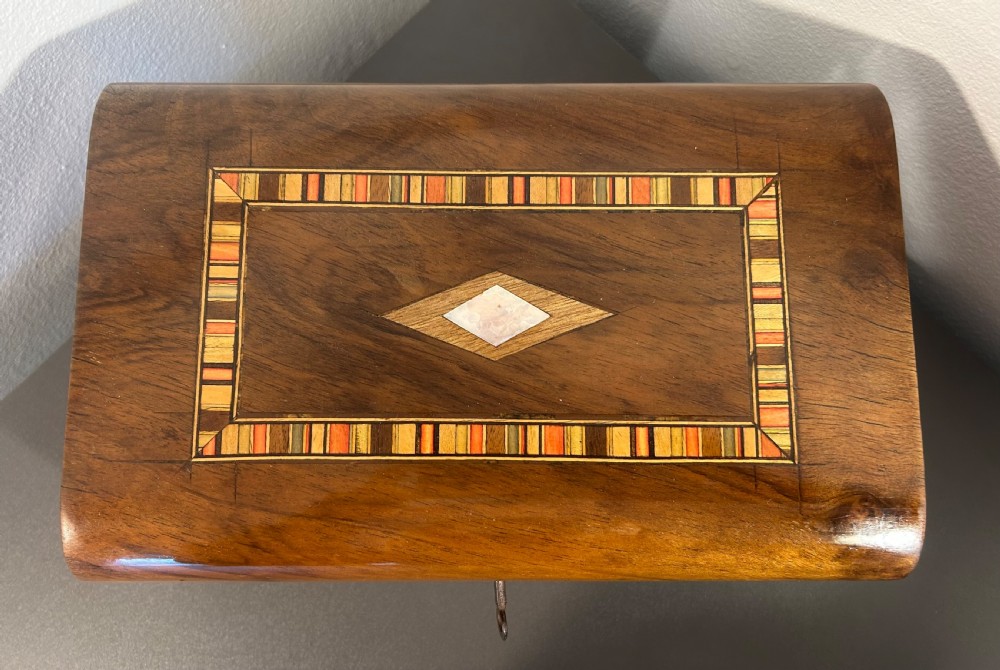 Victorian burr walnut wooden box with a geometric mosaic inlay border, central mother of pearl lozenge motif, and key in the front lock. View XI