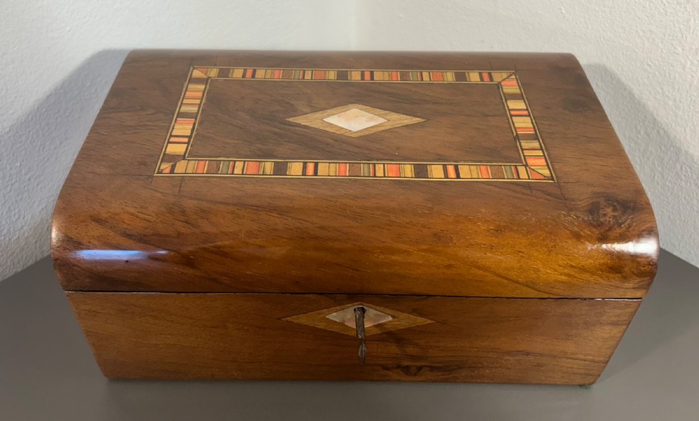 Victorian burr walnut wooden box with a geometric mosaic inlay border, central mother of pearl lozenge motif, and key in the front lock. View XII