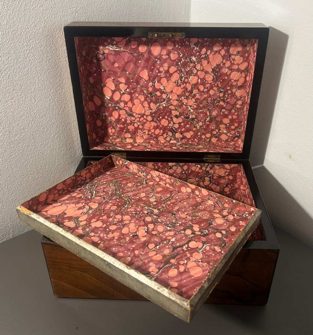 A rectangular warm brown figured walnut box featuring a brass cartouche on the lid and a brass escutcheon with a key. View X