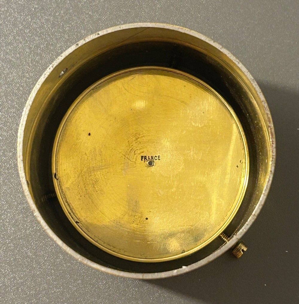 A circular Victorian brass table compass featuring a glass bezel, engraved directional dial, and an outer brass ring with threaded screws. View XIV