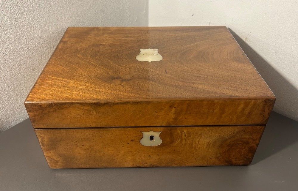 A Victorian figured walnut jewellery box with a mother-of-pearl shield cartouche on the lid and a matching escutcheon on the front.