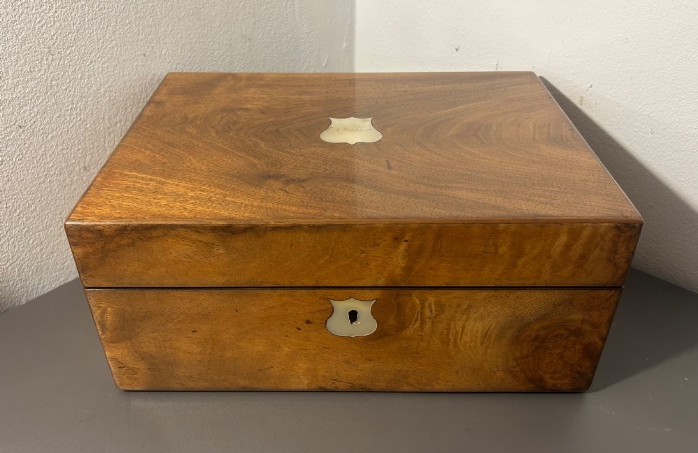 A Victorian figured walnut jewellery box with a mother-of-pearl shield cartouche on the lid and a matching escutcheon on the front. View II