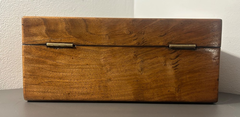 A Victorian figured walnut jewellery box with a mother-of-pearl shield cartouche on the lid and a matching escutcheon on the front. View V
