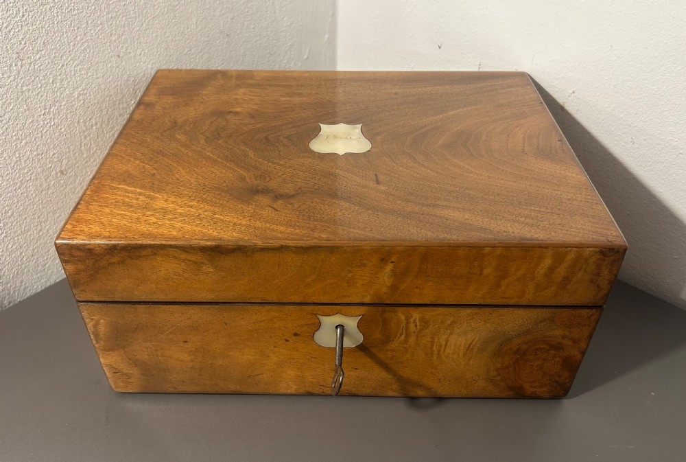 A Victorian figured walnut jewellery box with a mother-of-pearl shield cartouche on the lid and a matching escutcheon on the front. View X