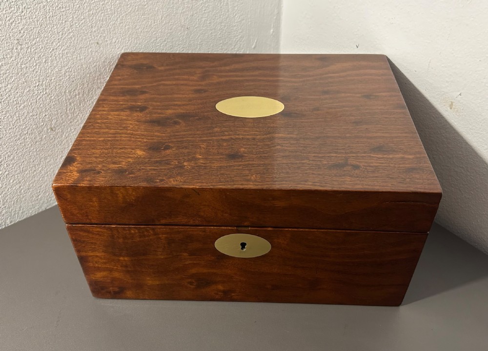 A rectangular Victorian plum mahogany jewellery box featuring a brass oval top cartouche and a matching brass keyhole escutcheon. View V