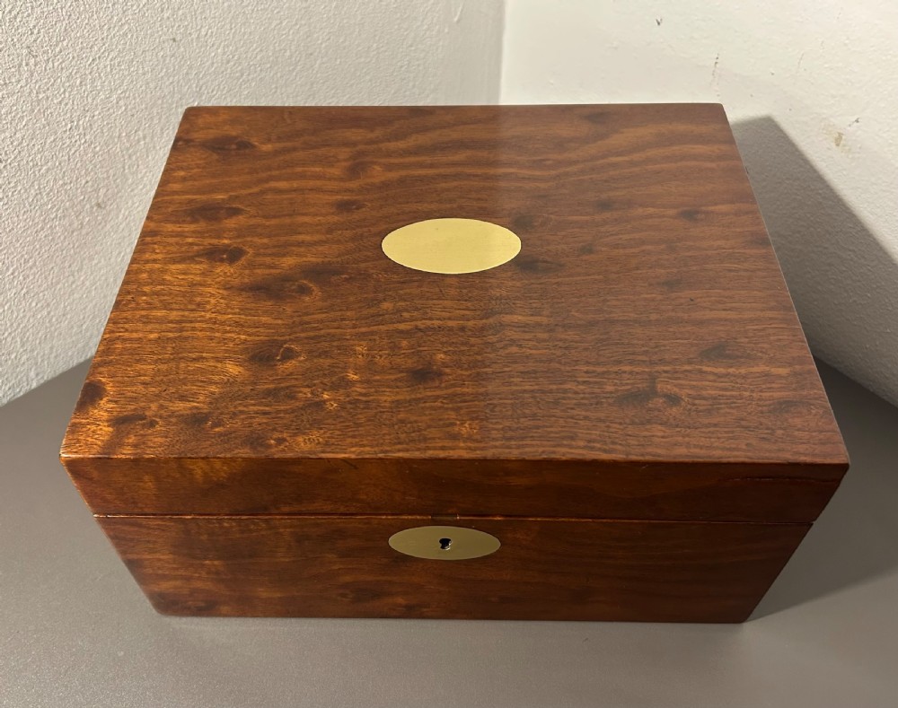 A rectangular Victorian plum mahogany jewellery box featuring a brass oval top cartouche and a matching brass keyhole escutcheon. View VI