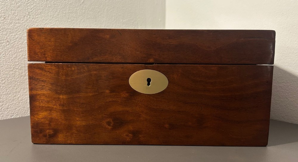 A rectangular Victorian plum mahogany jewellery box featuring a brass oval top cartouche and a matching brass keyhole escutcheon. View VII