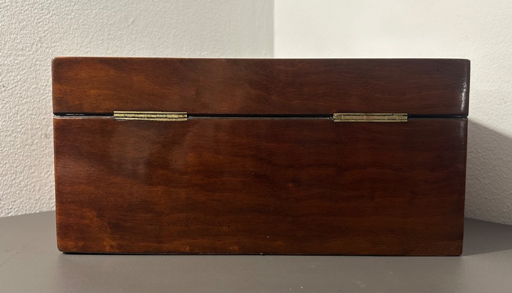 A rectangular Victorian plum mahogany jewellery box featuring a brass oval top cartouche and a matching brass keyhole escutcheon. View IX