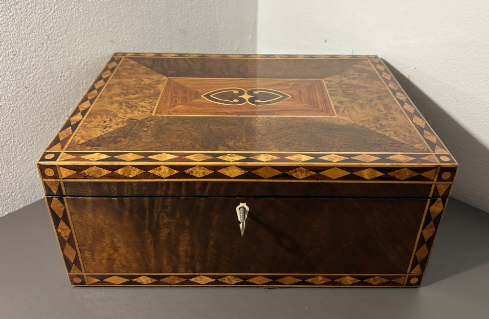 A rectangular Victorian specimen wood box featuring geometric parquetry inlay, a central heart motif on the lid, and a keyhole on the front. View IV
