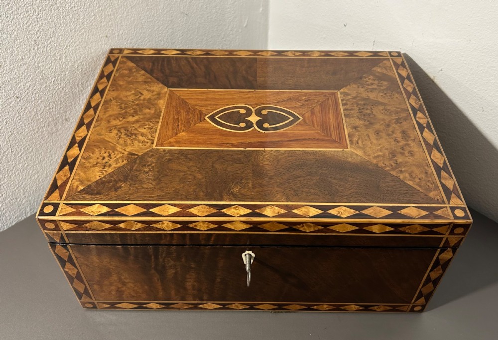 A rectangular Victorian specimen wood box featuring geometric parquetry inlay, a central heart motif on the lid, and a keyhole on the front. View V
