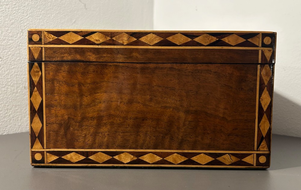 A rectangular Victorian specimen wood box featuring geometric parquetry inlay, a central heart motif on the lid, and a keyhole on the front. View VII