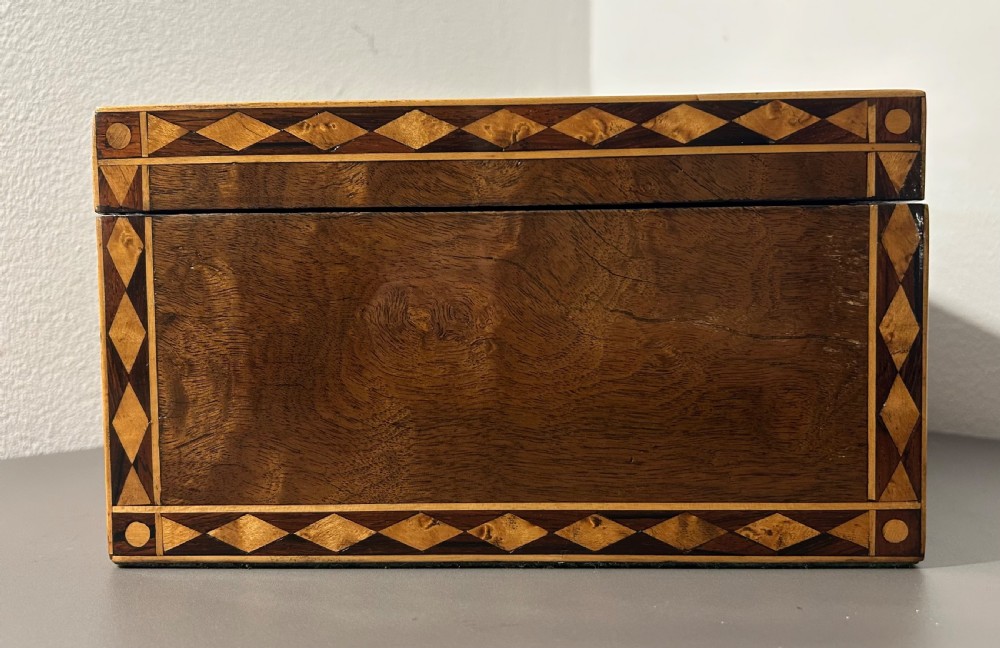 A rectangular Victorian specimen wood box featuring geometric parquetry inlay, a central heart motif on the lid, and a keyhole on the front. View IX