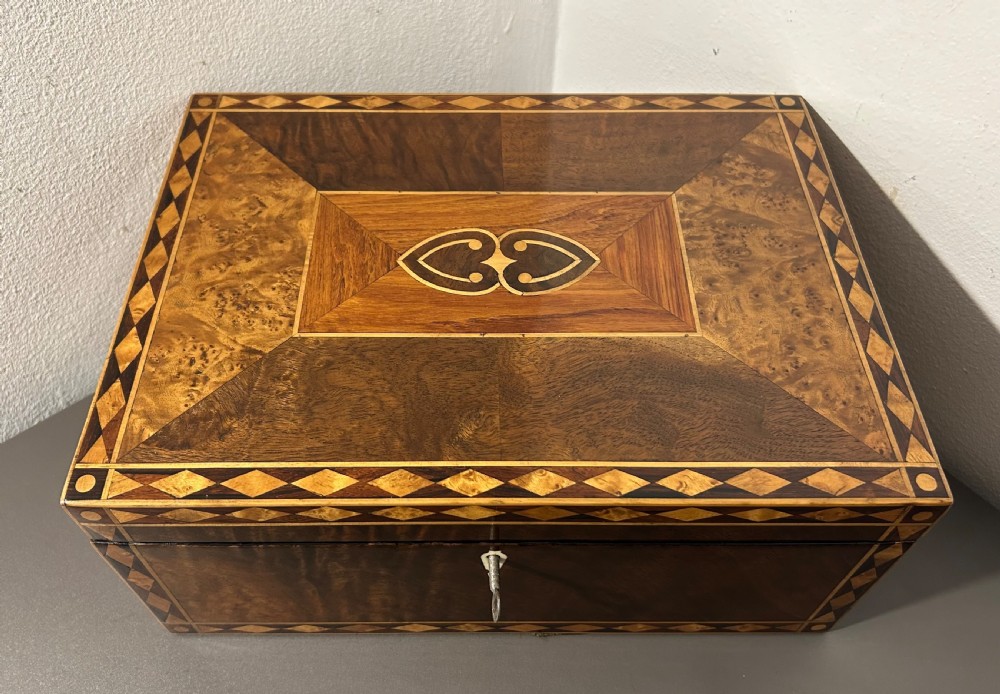 A rectangular Victorian specimen wood box featuring geometric parquetry inlay, a central heart motif on the lid, and a keyhole on the front. View X