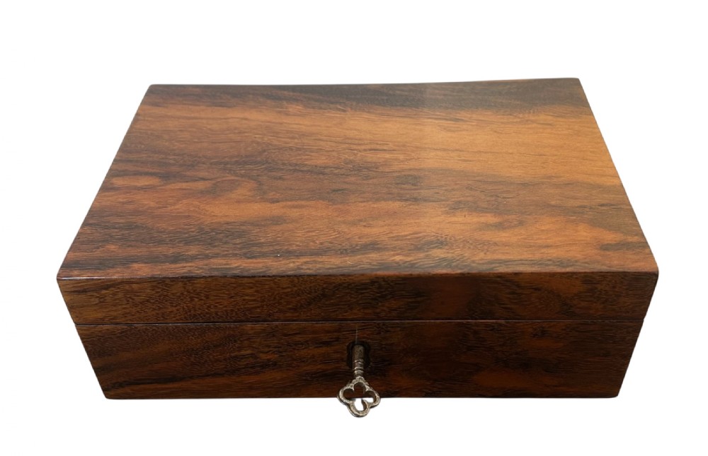 A rectangular Victorian table box featuring highly figured laburnum wood veneer and a central keyhole with key.