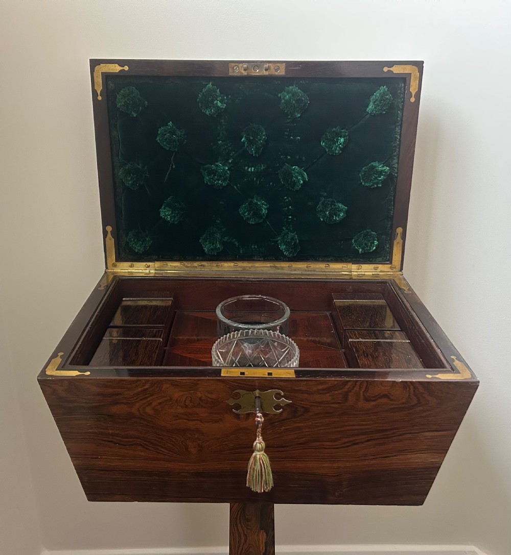 A Regency rosewood teapoy featuring a sarcophagus-shaped caddy top, brass escutcheon with key and tassel, set upon a central column and a four-pointed concave base. View XIII