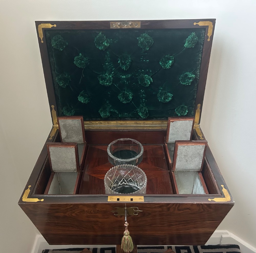 A Regency rosewood teapoy featuring a sarcophagus-shaped caddy top, brass escutcheon with key and tassel, set upon a central column and a four-pointed concave base. View XIV