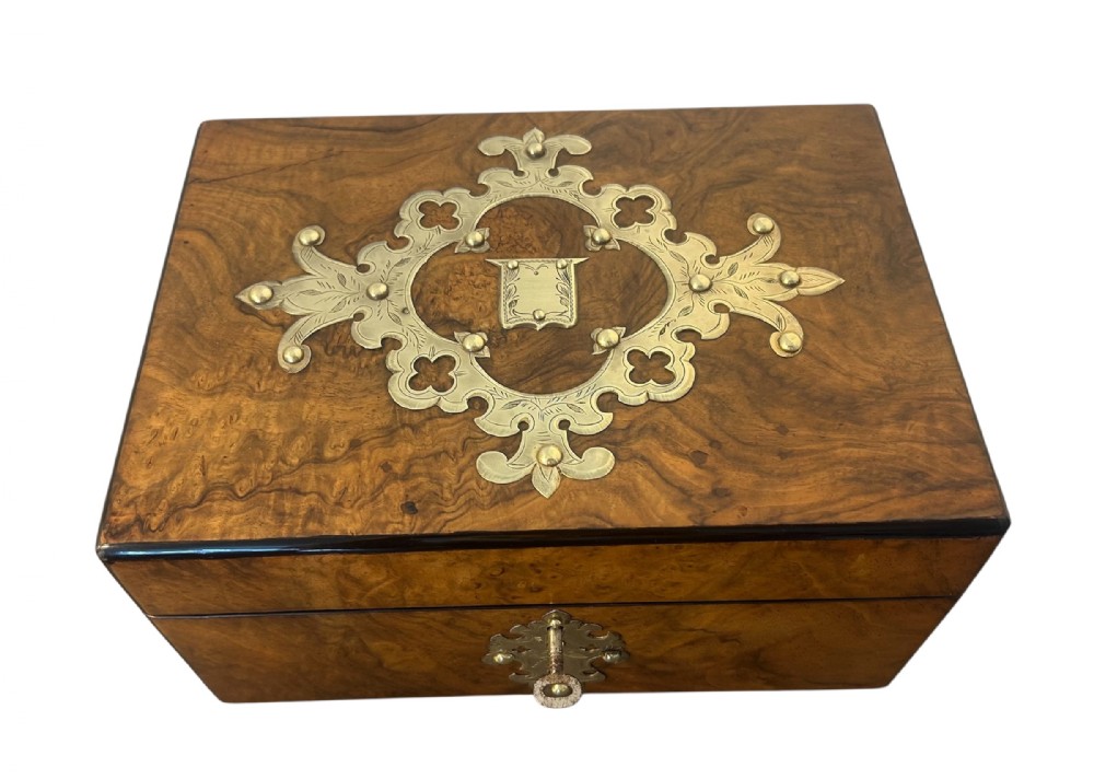 Victorian burr walnut jewellery box featuring ornate engraved brass strapwork and a keyhole escutcheon.