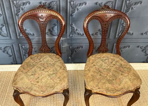 fig 2. A pair of Victorian carved dark wood side chairs featuring open-work balloon backs, patterned tapestry upholstered seats, and cabriole legs.