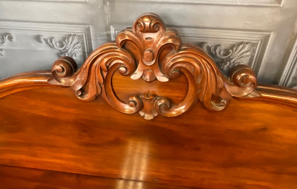 A Victorian mahogany pedestal sideboard featuring a carved arched backboard, flame mahogany veneer panels, and twin pedestal cupboards. View VIII