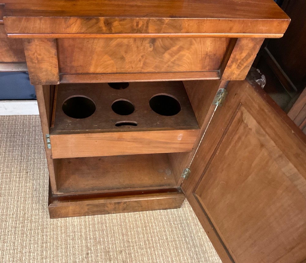 A Victorian mahogany pedestal sideboard featuring a carved arched backboard, flame mahogany veneer panels, and twin pedestal cupboards. View XIII
