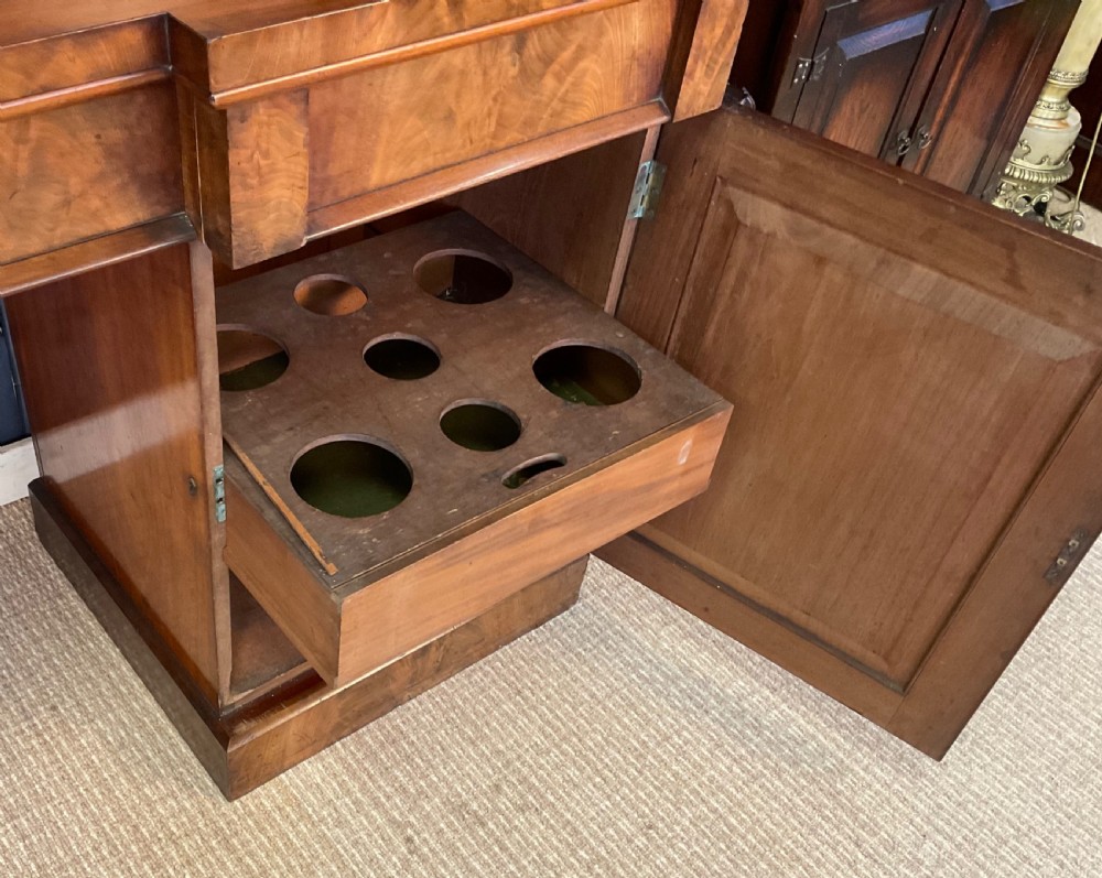 A Victorian mahogany pedestal sideboard featuring a carved arched backboard, flame mahogany veneer panels, and twin pedestal cupboards. View XIV