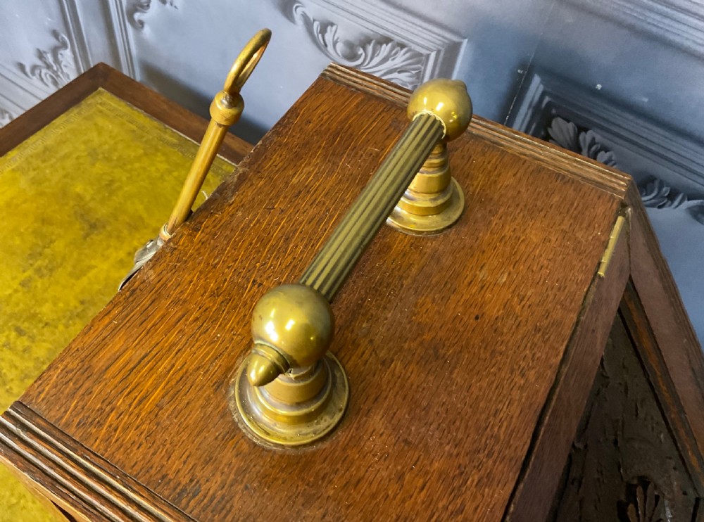 A Victorian carved oak coal scuttle featuring a brass top handle and a sloped front panel relief-carved with a mythical sea creature. View VI