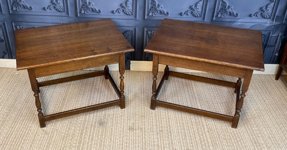 A matching pair of dark oak rectangular coffee tables featuring turned legs and low perimeter stretchers. View IV