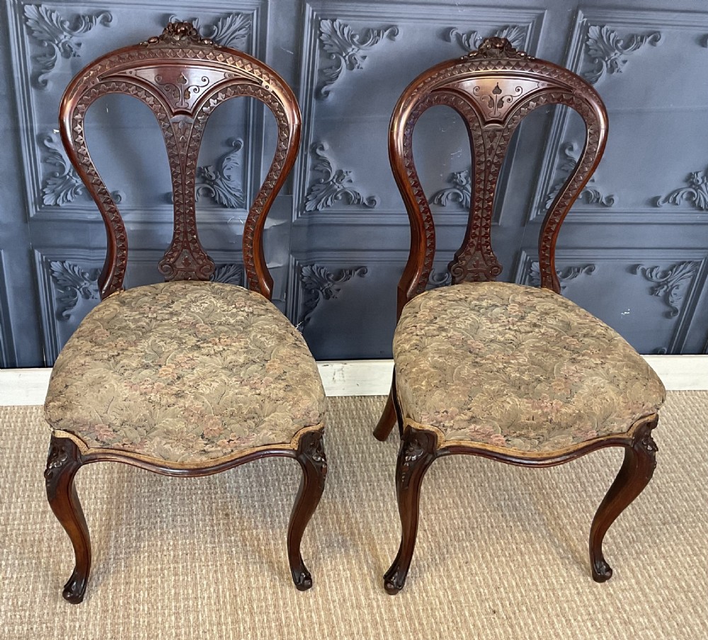 A pair of Victorian carved dark wood side chairs featuring open-work balloon backs, patterned tapestry upholstered seats, and cabriole legs. View II
