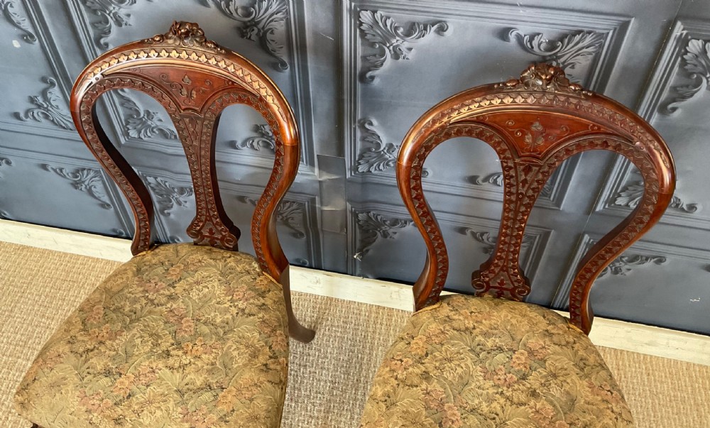 A pair of Victorian carved dark wood side chairs featuring open-work balloon backs, patterned tapestry upholstered seats, and cabriole legs. View IV