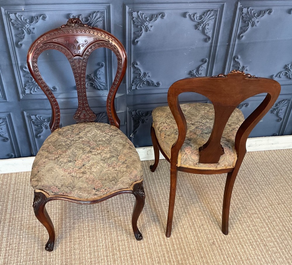 A pair of Victorian carved dark wood side chairs featuring open-work balloon backs, patterned tapestry upholstered seats, and cabriole legs. View VIII