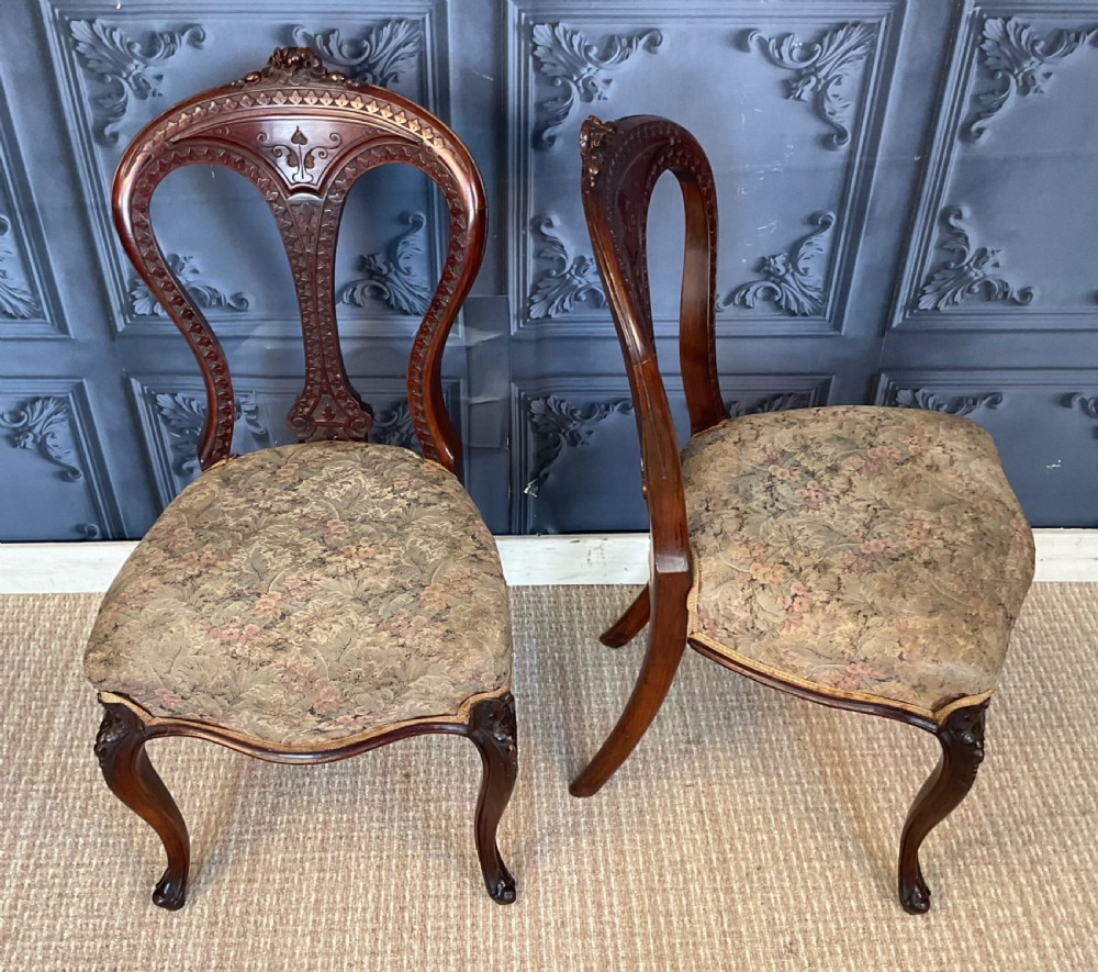 A pair of Victorian carved dark wood side chairs featuring open-work balloon backs, patterned tapestry upholstered seats, and cabriole legs. View IX