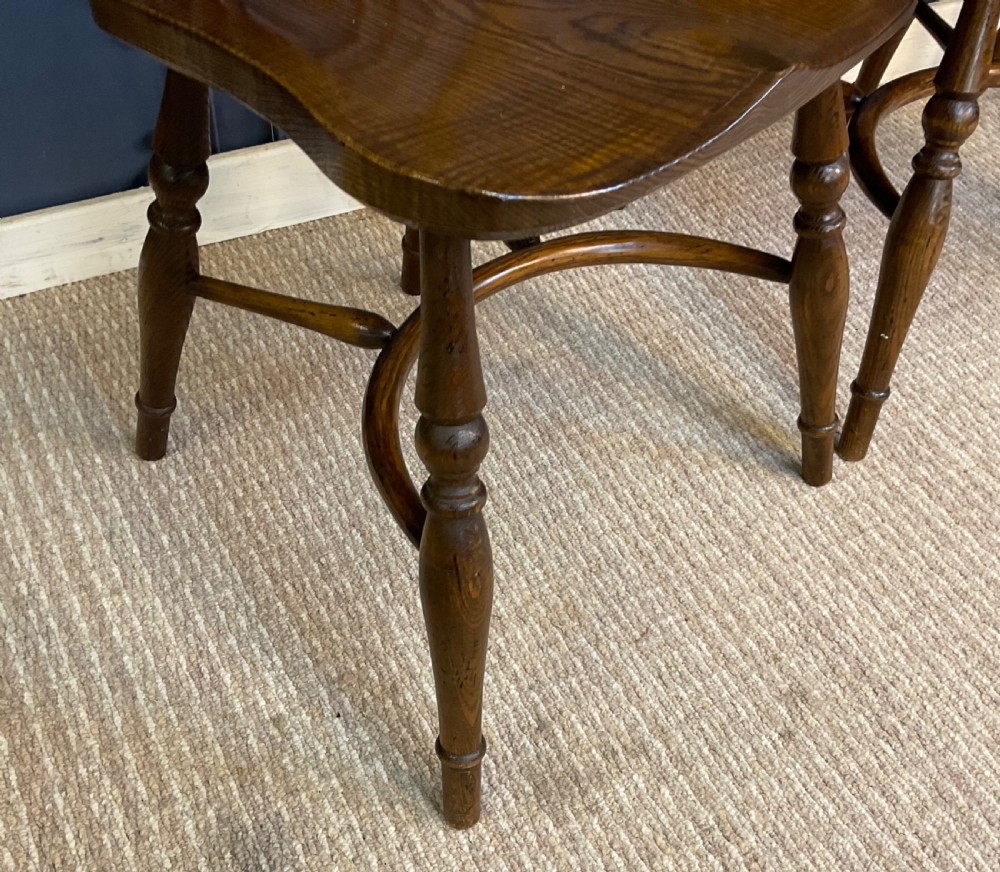 A set of four warm brown wooden Windsor style dining chairs with hoop backs, pierced central splats, and turned legs. View VIII