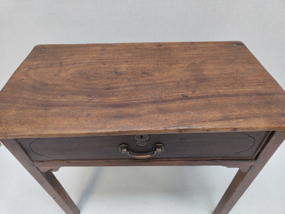 A rustic brown timber side table featuring a single central drawer with a brass drop handle and straight square legs. View III