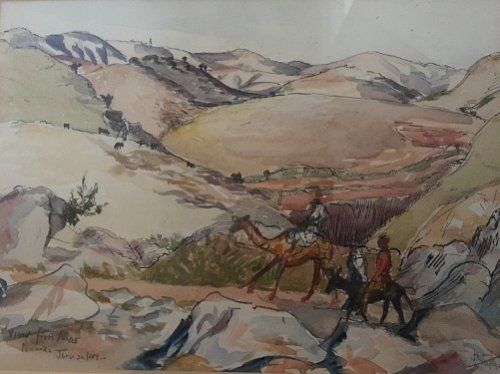fig 1. A framed 1940 watercolour landscape depicting rolling desert hills with figures on camels, set within a cream mount and gilt wooden frame.