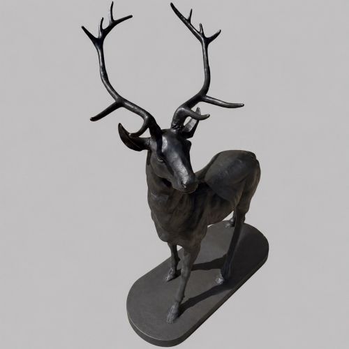 fig 1. A patinated dark bronze sculpture depicting a standing young stag with antlers fixed onto an oval base.