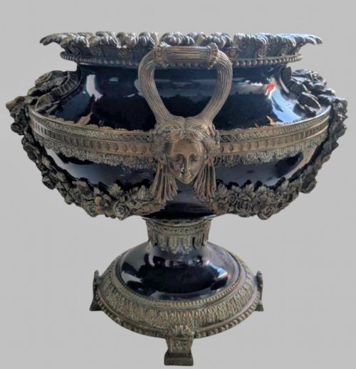 fig 2. A pair of deep cobalt blue glazed ceramic urn-shaped jardinieres adorned with ornate gilt bronze mounts, floral swags, and decorative handles, set on footed bases.