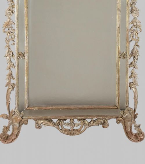 fig 2. An antique nineteenth-century French giltwood mirror featuring elaborate carved cresting with foliage motifs and an arched frame.