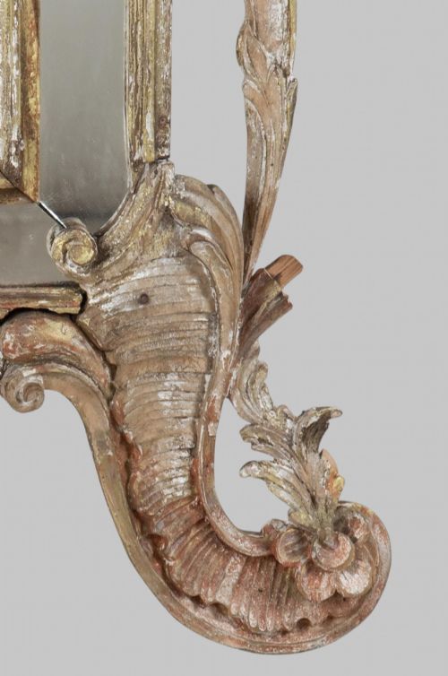 fig 3. An antique nineteenth-century French giltwood mirror featuring elaborate carved cresting with foliage motifs and an arched frame.