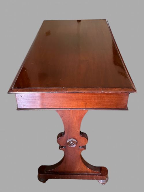 fig 2. A rectangular mahogany library table featuring three frieze drawers with round timber handles and a lower turned stretcher resting on shaped trestle feet.