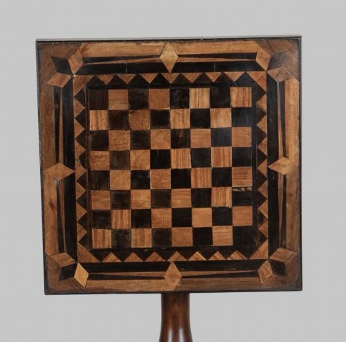 fig 2. A Georgian tilt-top games table with a square geometric inlaid chessboard top mounted on a turned pedestal column and triform base with ball feet.