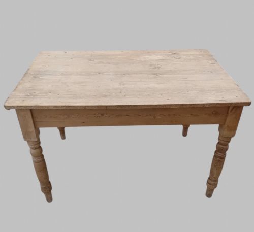 fig 1. A late 19th-century rectangular pine farmhouse table featuring a scrubbed wood plank top, a frieze drawer with turned wooden knobs, and turned legs.