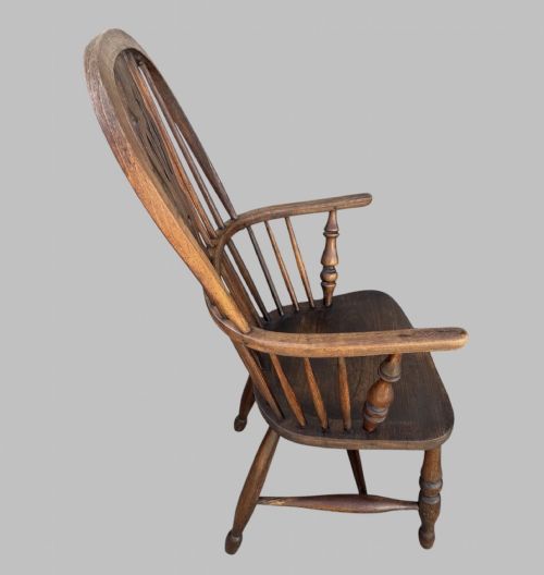 fig 1. A nineteenth-century hoop-back Windsor armchair crafted from ash and elm wood, featuring a shaped saddle seat, pierced splat, slender back spindles, turned front legs, and an H-stretcher.
