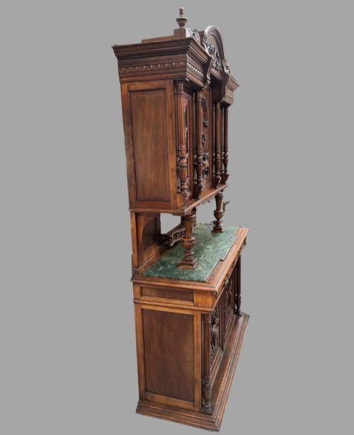 fig 4. A late 19th-century French Provincial walnut dresser featuring hand-carved relief panels, glazed side cabinets, turned support columns, and a green marble insert surface.