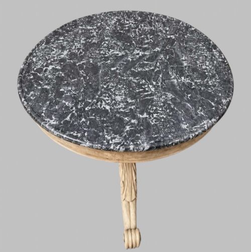 fig 1. A circular antique French gueridon table featuring a dark grey mottled marble top supported by a carved bleached walnut pedestal and tripod scrolled legs.