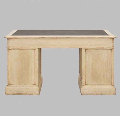 fig 2. A circa 1900 bleached oak pedestal desk featuring nine drawers with brass swing handles and a dark inset leather writing surface.