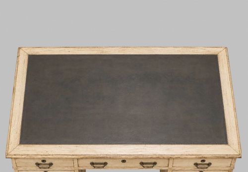 fig 3. A circa 1900 bleached oak pedestal desk featuring nine drawers with brass swing handles and a dark inset leather writing surface.