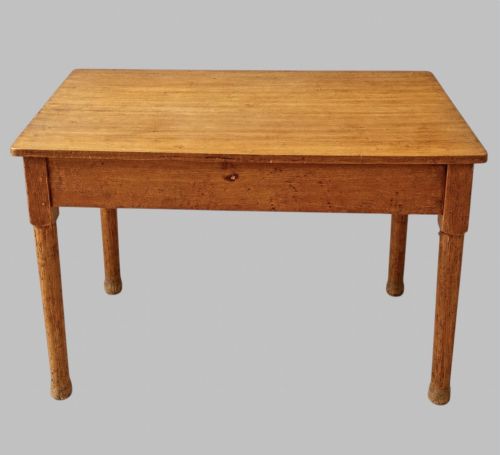 fig 2. An early 20th-century light oak work table featuring a rectangular top, two frieze drawers with brass cup handles, and turned legs.
